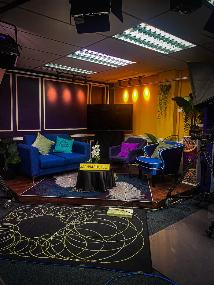 A lounge set with blue sofas, coloured lighting and patterned floor markings